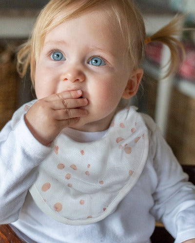 toddler wearing dusty pink bamboo bib