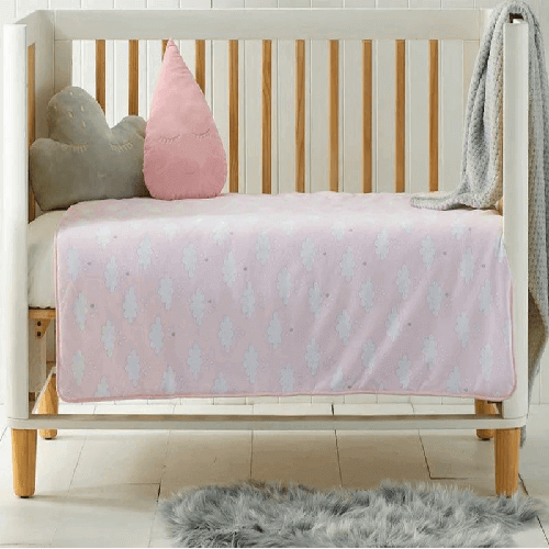 Pink cot comforter with white clouds