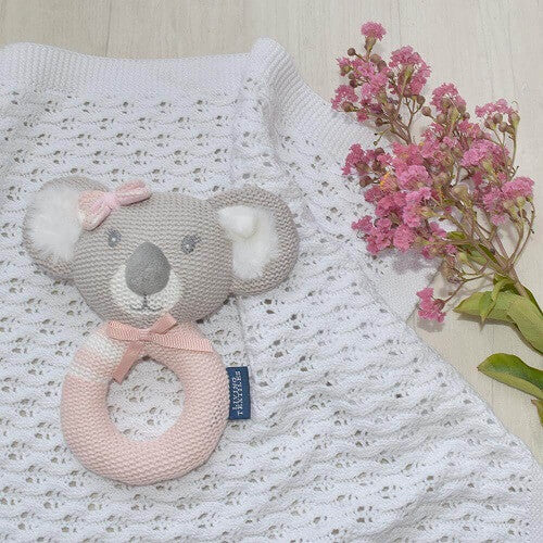 Pink koala knitted ring rattle displayed on a blanket