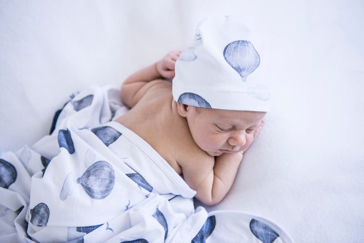 newborn in cloud chaser swaddle and beanie