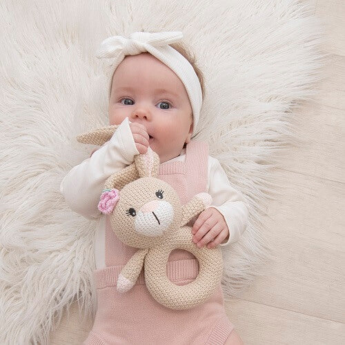 baby holding bunny knit ring rattle