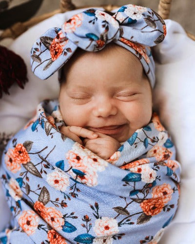 newborn in vintage blossom swaddle and topknot