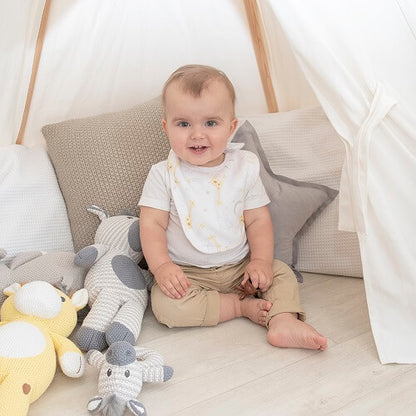 Baby wearing white cloud bib with giraffes