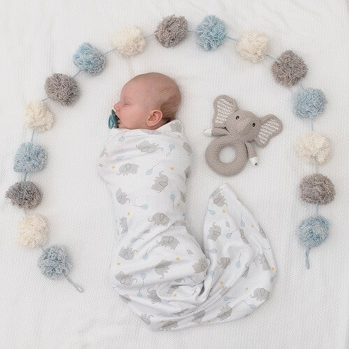 baby swaddled in elephant jersey and knitted elephant rattle