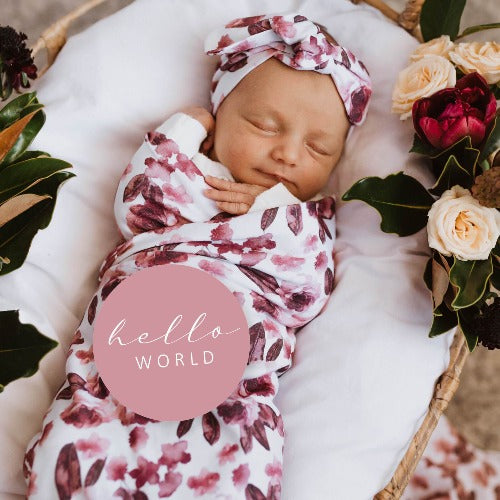 baby in fleur swaddle with jewel milestone card