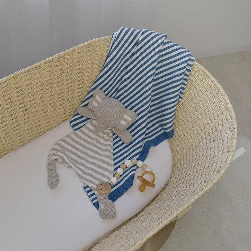 navy and white knitted blanket draped over bassinet