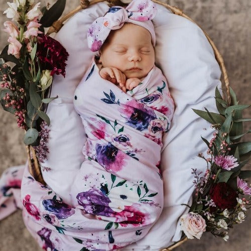 newborn in floral kiss jersey swaddle and topknot